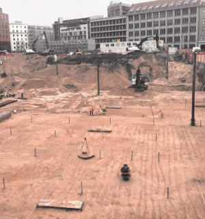 Baugrube mit mehreren Baugeräten und Bauarbeitern für den Neubau des Axel-Springer-Verlags in Berlin