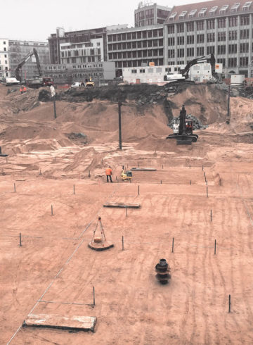 Excavation pit with several construction machines and construction workers for the new building of the Axel Springer publishing house in Berlin