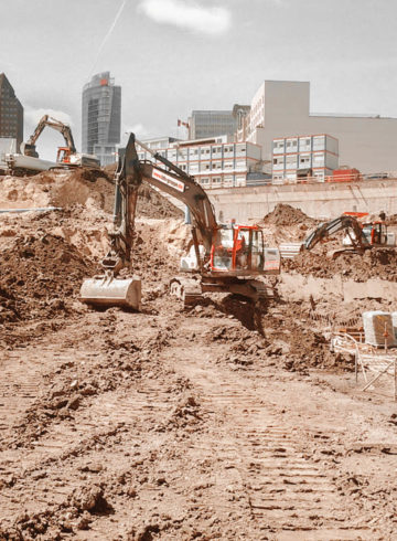 Excavation pit of the Mall of Berlin with several excavators and trucks, in the background the DB building at Postdamer Platz.