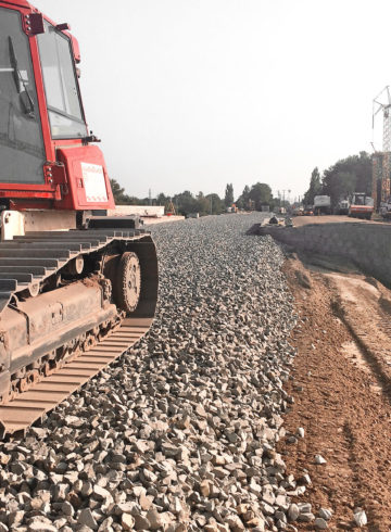a roller from BTB applies railway ballast for a new railway embankment