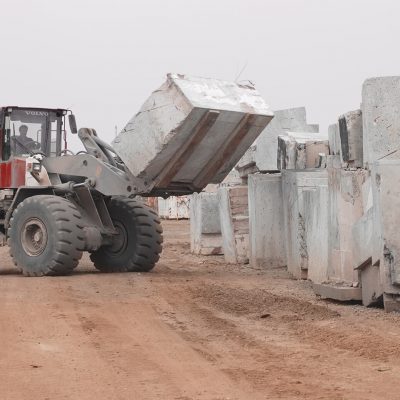 Eine schwere Baumaschine befördert große Betonblöcke