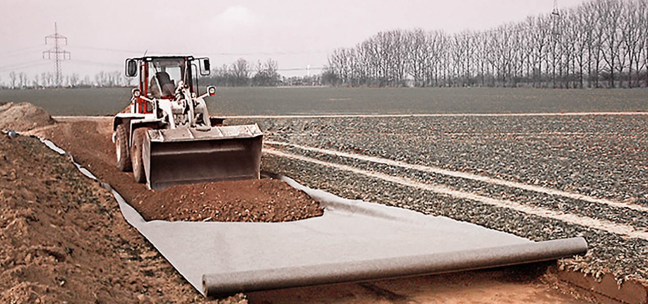 ein Schaufelbagger errichtet auf einem Feld eine Baustraße